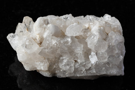 sample of rough druse of clear quartz rock on black background close upの写真素材