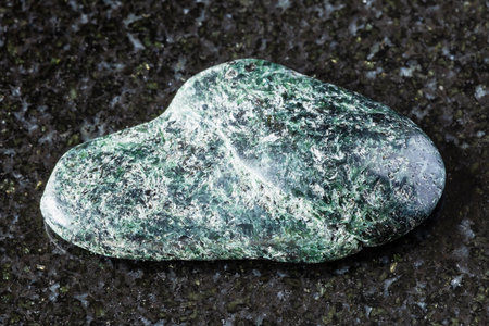 sample of polished actinolite rock on black granite background close up from North Karelia, Russiaの写真素材