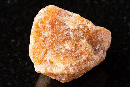 sample of rough heliolite sunstone rock on black granite background close upの写真素材