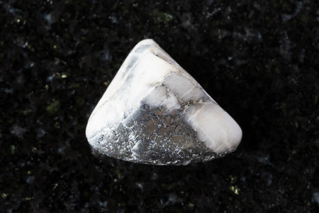 sample of polished skutterudite mineral on black granite background close up from Tuva, Russiaの写真素材