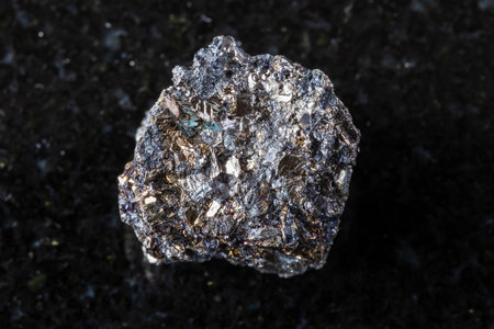 sample of rough native bismuth mineral on black granite background close up from Hartenstein, Germanyの写真素材