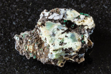 sample of rough tenorite mineral with chrysocolla on black granite background close up from Southern...