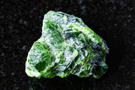 sample of rough chrome diopside mineral on black granite background close up from Yakutia, Russiaの写真素材