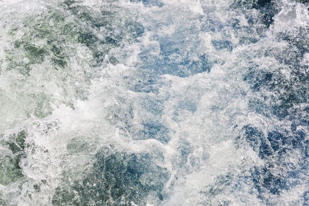 water churned up by propeller behind boat's stern in Avacha bay of Pacific Ocean on spring day,...