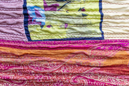 textile background - textured surface of pleated silk patchwork fabric close up