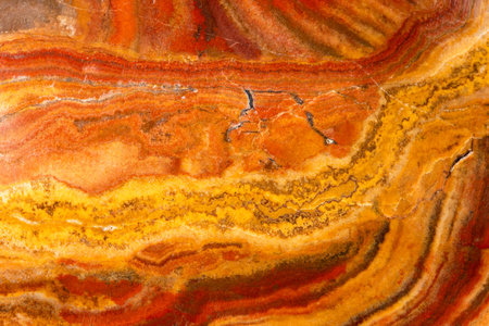 gemological background - polished surface of banded cave onyx rock close up