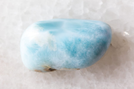 sample of tumbled larimar mineral on white marble background close up from Dominicana