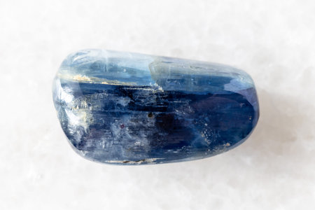 sample of polished blue kyanite gemstone on white marble background close up from Nepal