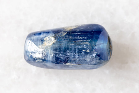 sample of tumbled blue kyanite gemstone on white marble background close up from Nepalの写真素材