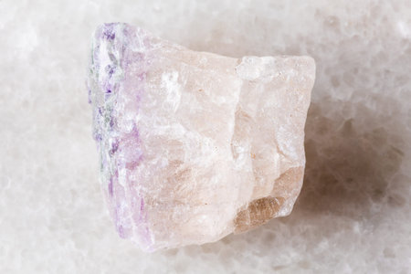 sample of unpolished fluorite rock on white marble background close up