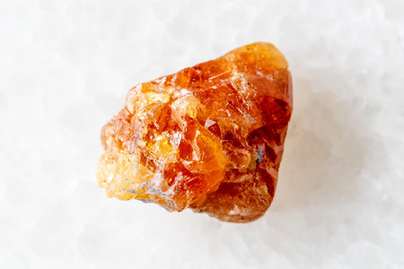 sample of unpolished scheelite mineral on white marble background close up from Middle Urals, Russia