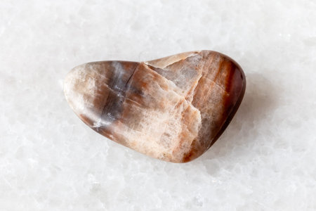 sample of polished nephelite rock on white marble background close up from Southern Urals, Russia
