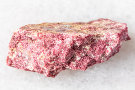 sample of raw thulite rock on white marble background close up from Norwayの写真素材