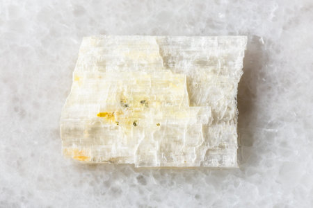 sample of rough eudidymite mineral on white marble background close up from Malawi