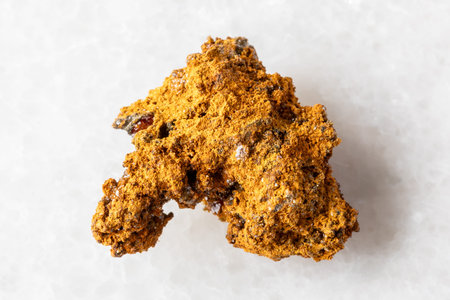sample of raw wulfenite ore on white marble background close up from Xinjiang, China