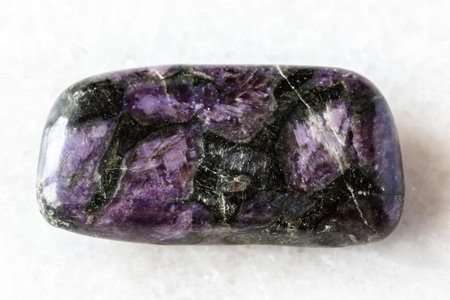 sample of polished mineral on white marble background close up