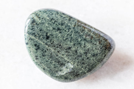 sample of polished green quartzite rock on white background close up