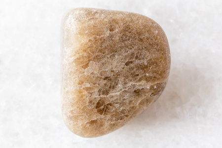 sample of polished cryolite rock on white marble background close up from Tuva, Russia