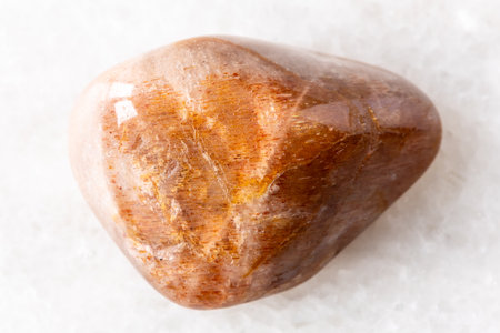 sample of tumbled iridescent feldspar mineral on white marble background close upの写真素材