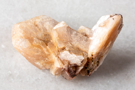 sample of raw stilbite crystals on white marble background close up