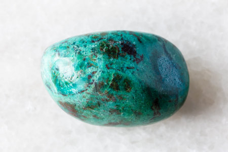 sample of tumbled chrysocolla mineral on white marble background close up from Peru