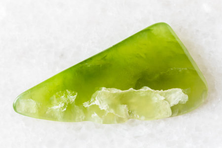 sample of polished vesuvianite mineral on white marble background close up