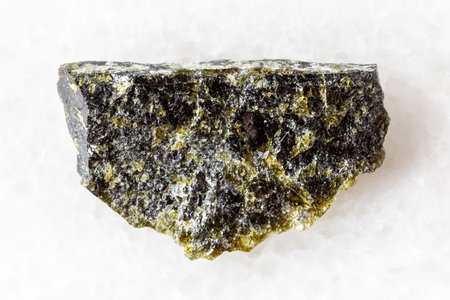 sample of raw diopside rock on white marble background close up from Kola Peninsula, Russia