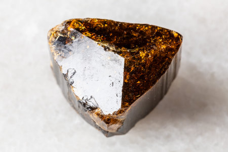 sample of raw dravite tourmaline mineral on white marble background close up from Madagascar