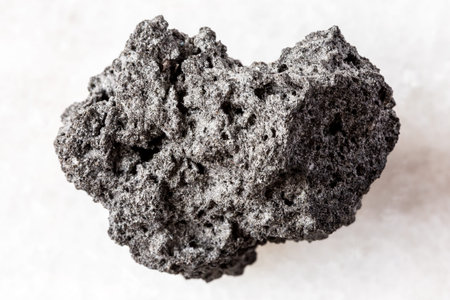 sample of rough pumice mineral on white marble background close up from Sicily, Italy