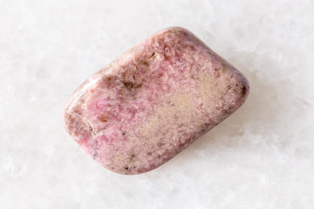 sample of polished pyroxmangite mineral on white marble background close up from Colorado, USA