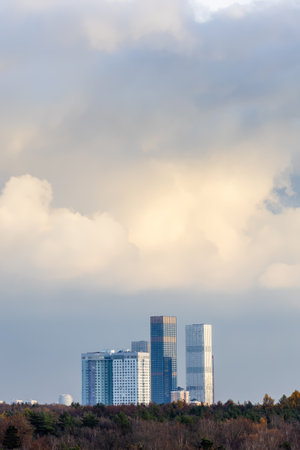 cloudy sky over new skyscrapers and city park on autumn dayの写真素材