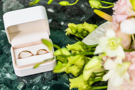 golden wedding rings in open box close up on marble tableの写真素材
