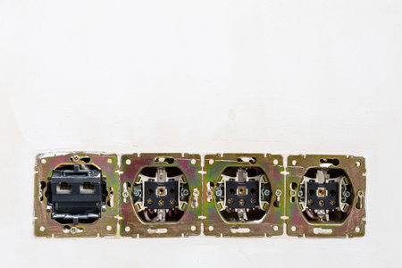 disassembled electrical sockets in plastered wall of room close up during renovation of city...