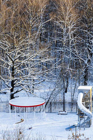 top view of snowy playground near sunlit city park on sunny winter dayの写真素材