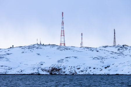 travel to Murmansk Oblast of Russia in winter season - communication towers on snowy coast of...