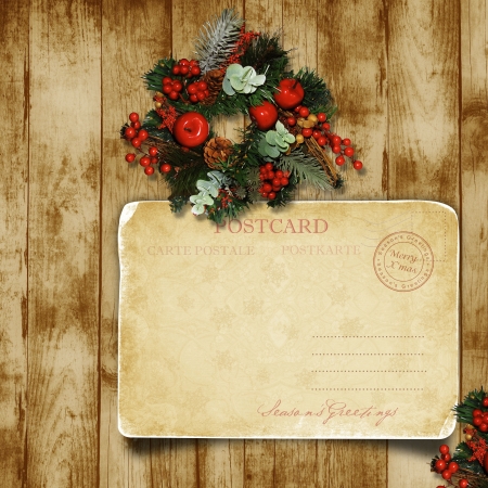 Christmas wreath on the wood door with a Christmas postcard の写真素材