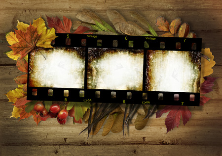 Film strip and autumn border on vintage wooden backgroundの写真素材