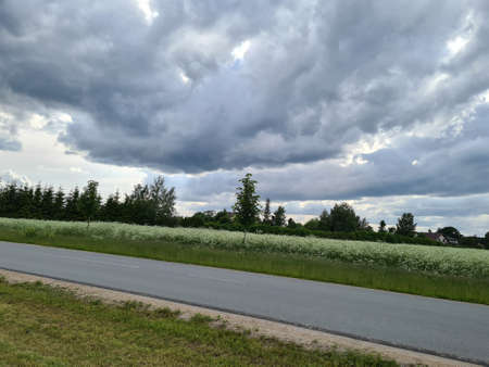 storm clouds getting together over grass meadowの写真素材