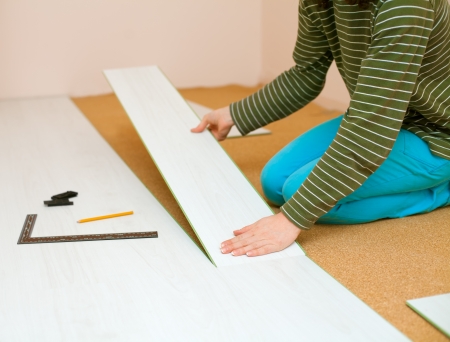 Woman lays laminate flooringの写真素材