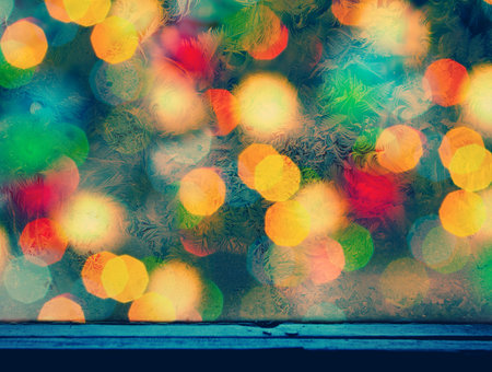 Grunge background from frosty pattern on the window and christmas light