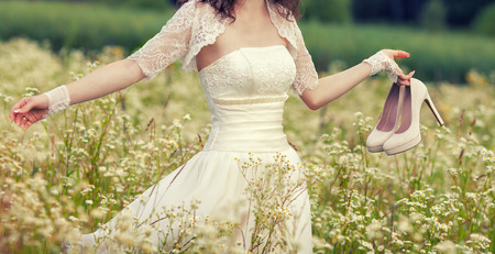 Young bride walking on flower meadowの写真素材