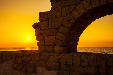 Remains of the ancient Roman aqueduct in ancient city Caesarea at sunset, Israel.の写真素材