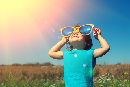Little girl with big sunglasses enjoys sun Little girl with big sunglasses enjoys sun