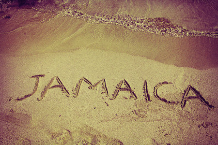 retro inscription Jamaica on beach sand