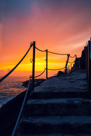 Stairways in rock over sea at sunset