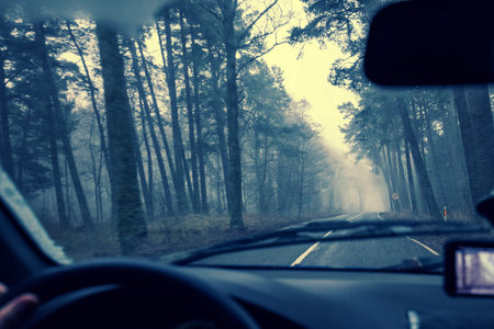 View from windscreen. Driving a car on road in blizzard