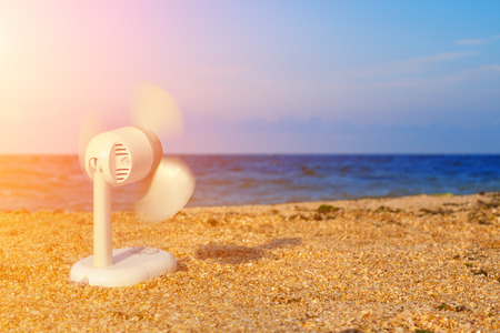 electric fan blowing on the beach in hot summerの写真素材