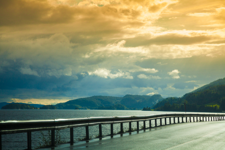 Mountain road with dramatic cloudy sunset  sky. Nature Norway. Polar circle. Lofoten islandsの写真素材