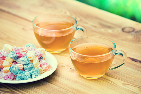 Two cup of green tea decorated with turkish delight on wooden tableの写真素材
