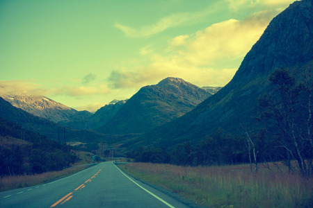Driving a car on the mountain road at sunrise. Road among mountains with morning sky. Landscape.  Beautiful nature Norway.の写真素材